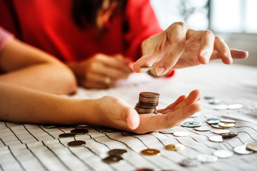 woman holding stack of coins in palm