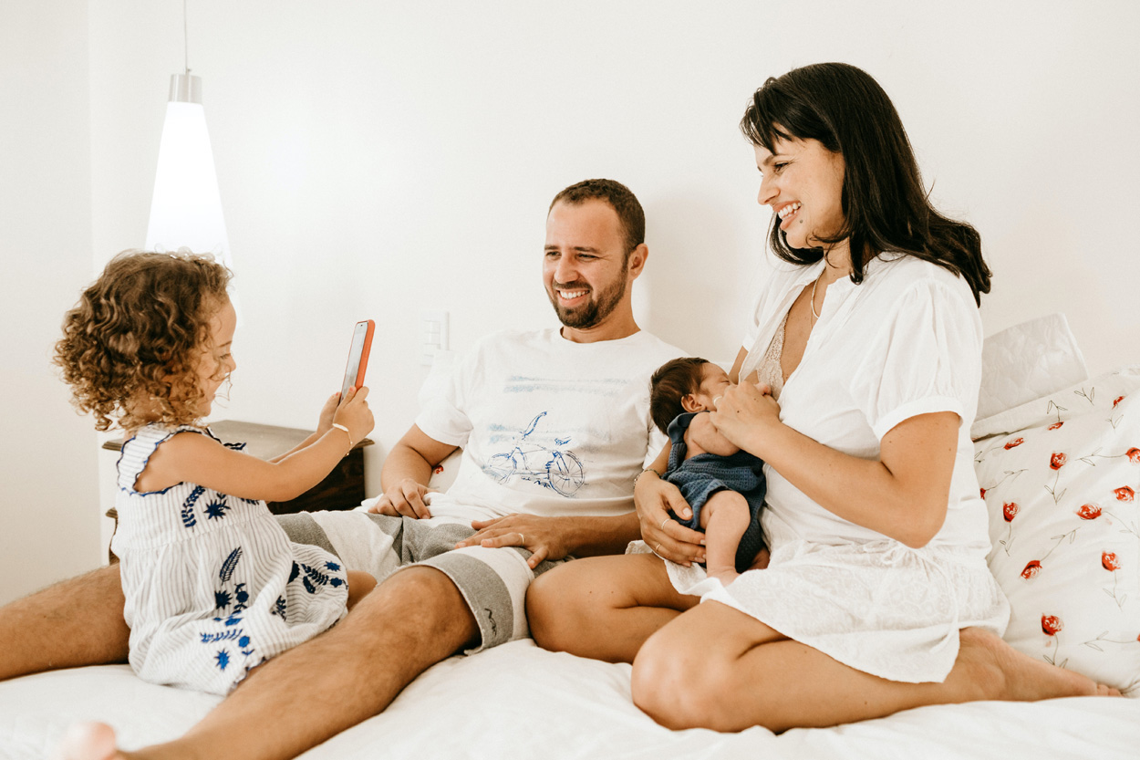 husband with wife and kids sitting in bed