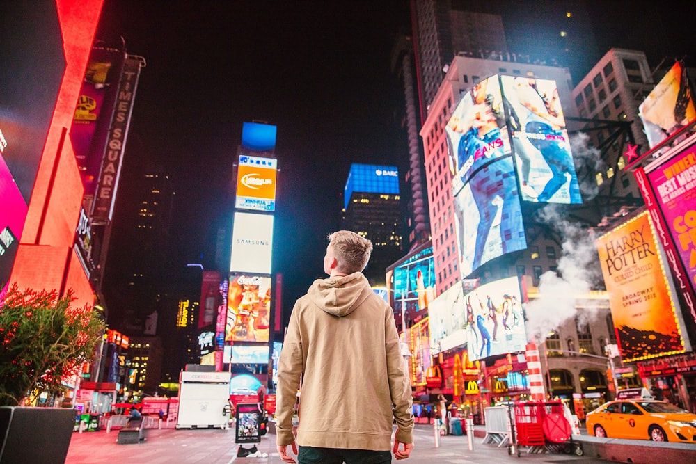 man looking at advertising in Times Square