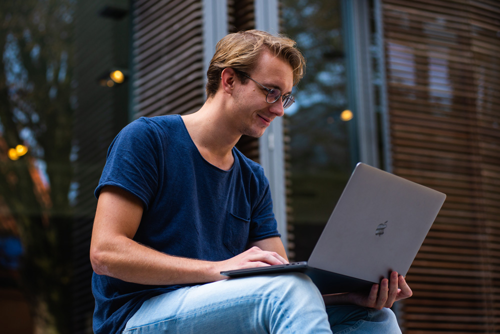 man on laptop sitting outside