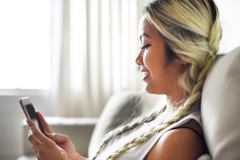 woman smiling viewing mobile phone